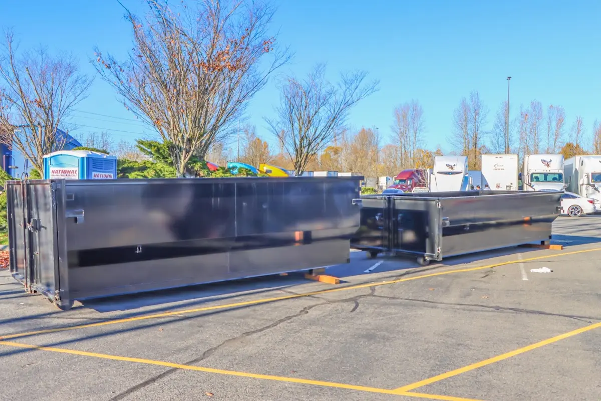 Professional dumpster rental service with roll-off container on residential driveway in Enid